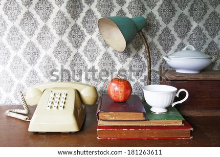 still life with old book,apple ,Push Button Telephone,lamp and tea cop on wooden table.
