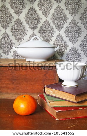 still life with old book,orange and coffee cup on wooden  table.