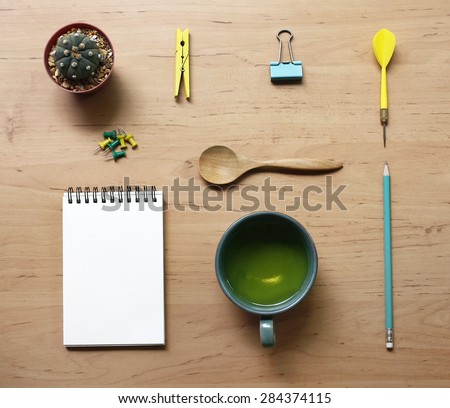 still life with tea cup and the contents of a workspace composed. Different objects on wooden table.