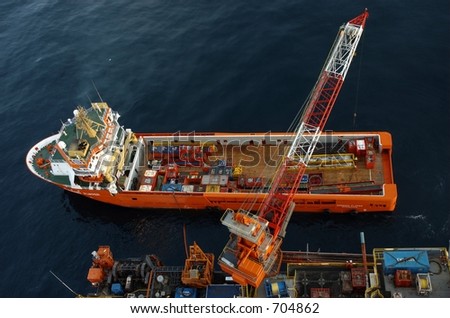 A supply ship being loaded and unloaded from on an offshore oil rig