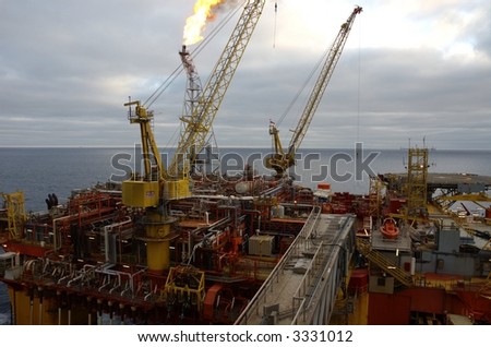 Burning flare tower above production area of floating oil rig