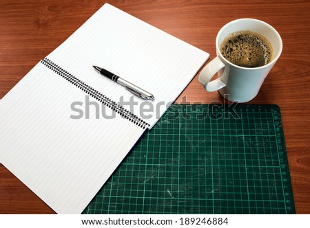 Green Cutting mats , notebook , pen , cup of coffee on the wood