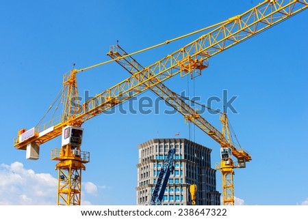 Inside place for tall buildings under construction and cranes under a blue sky