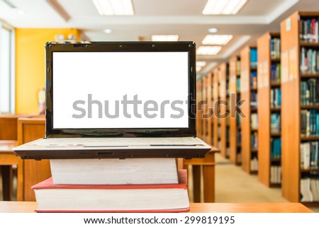 Laptop on table, on bookshelf background,blank screen,library
