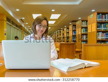 Student studying in the library with laptop at the university