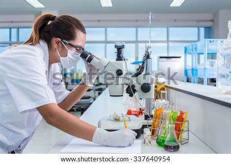 Serious clinician studying chemical element on tester and lecture in laboratory