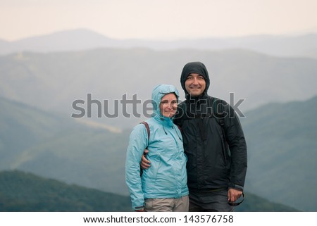 Happy couple at cold day on mountain trail