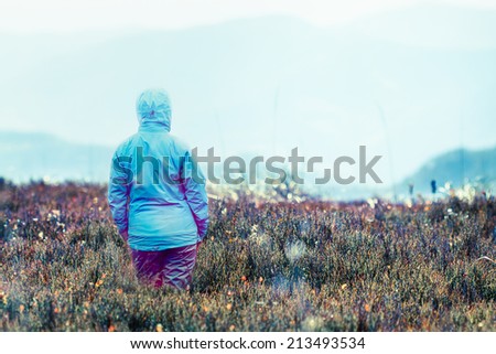 Woman looking at mountains in the autumn morning. Space for text