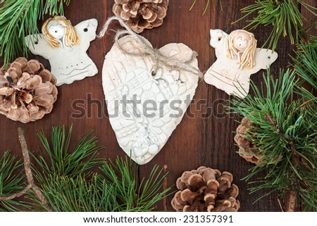 Earthen angels and heart decorated with pine twigs and pine cones
