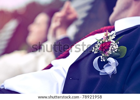 Newlyweds hands with rings and wedding bouquet (focus on flower)