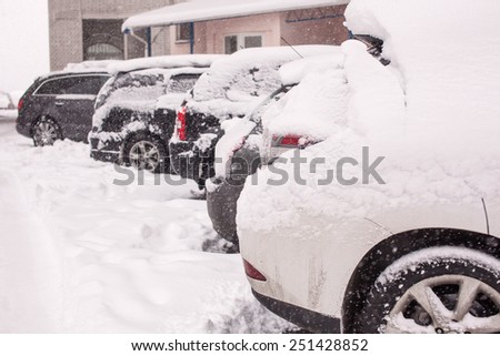 Snow-covered cars during a winter blizzard