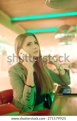 Young woman talking on a cell phone in cafe