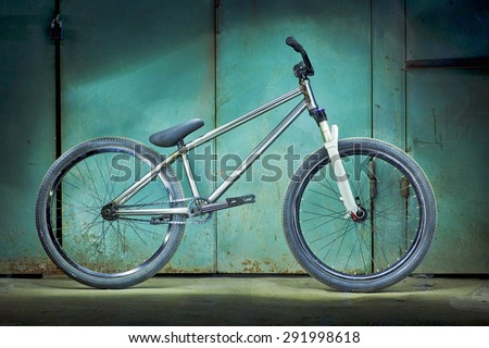 Silver bicycle on a green garage background with light effects