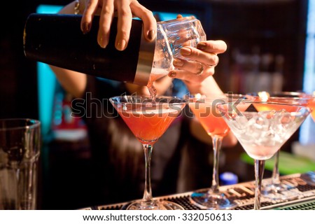 The girl bartender prepares a  cocktail in the nightclub.
