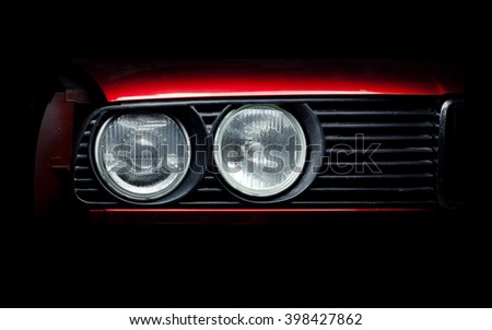 Headlights of the old red car close-up photo.