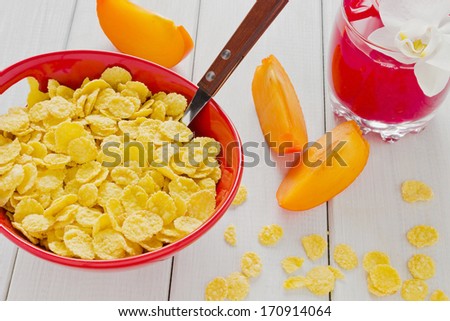 cornflakes, sliced fruit and a drink on the table
