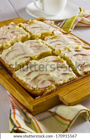 cut into portions of apple cake on wooden platter