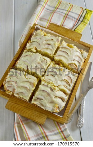 cut into portions of apple cake on wooden platter