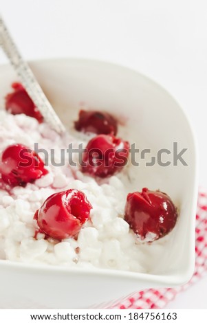cottage cheese and canned cherries in a white bowl