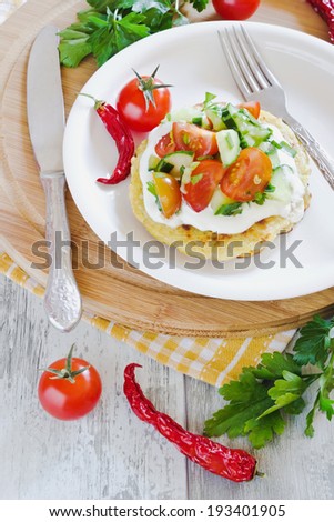 potato pancakes with sour cream and fresh vegetables on the table
