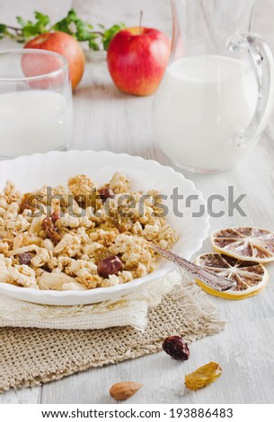 cold cereal in a bowl, apples and a pitcher of milk