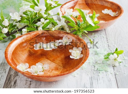 bowl of water, cosmetic salt and blooming cherry branch. spa.selective focus