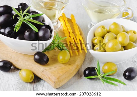 marinated olives, rosemary and olive oil on a cutting board.selective focus.health and diet