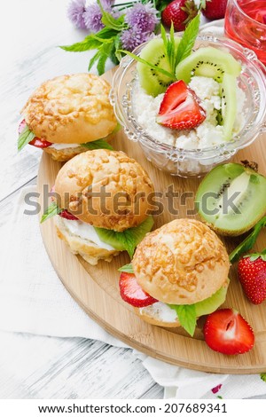 sandwiches with cottage cheese and fruit on a cutting board on the table.selective focus. health and diet concept