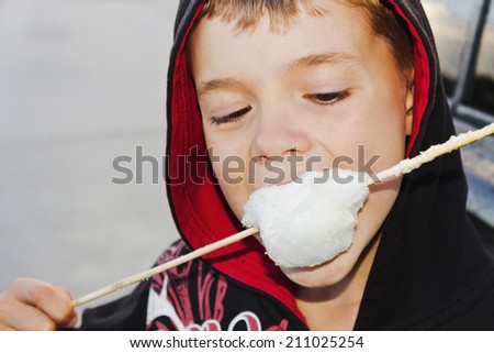 boy in the hood eating cotton candy.selective focus