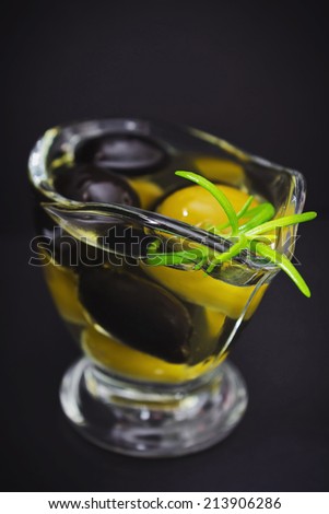 different marinated olives in olive oil on a black background. selective focus.health and diet
