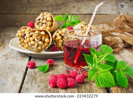 drink of fresh raspberries and waffle cones with corn balls on old wooden table. festivals and events.
