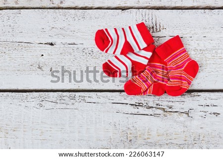 baby red striped socks on a white wooden background. children\'s clothing.copy space for text