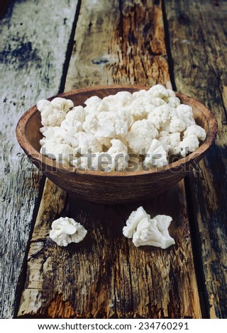 pieces of cauliflower in a wooden bowl on the old wooden background.health and diet food