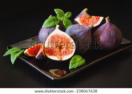 fresh figs in a plate on a black wooden background.health and diet food