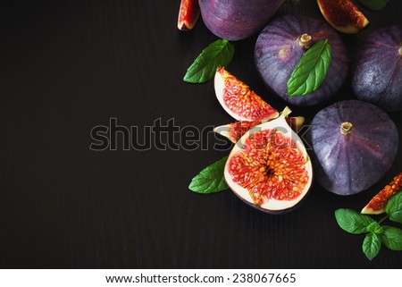 delicious fresh figs and mint leaves on a black wooden background. health and diet food. copy space background