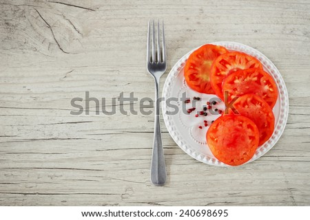 sliced ripe tomatoes on a plate on a wooden background.health and diet food. copy space background