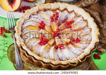 fruit cake with peaches and berries on a green background. sweet breakfast. traditional pastries.