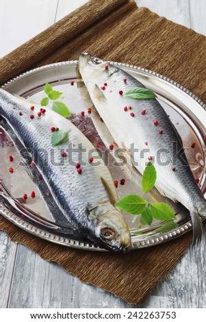 salted herring with spices in an iron dish on a wooden table.healthy sea food