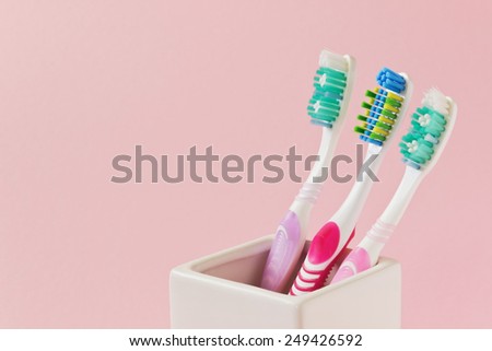 different toothbrushes in a bowl on a colored background. care and hygiene of teeth. copy space background