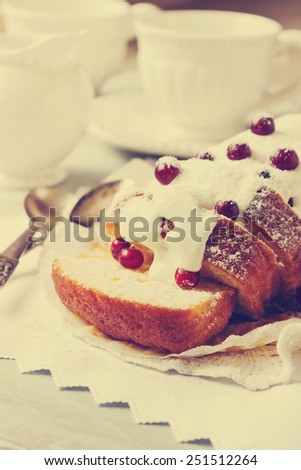 freshly baked sliced cupcake with icing and fresh cranberries on the holiday table. holiday meal. toning retro style. selective focus