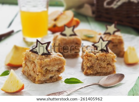 pieces of apple pie with chocolate stars and apple juice on parchment paper. homemade pastries. holidays and events. selective focus