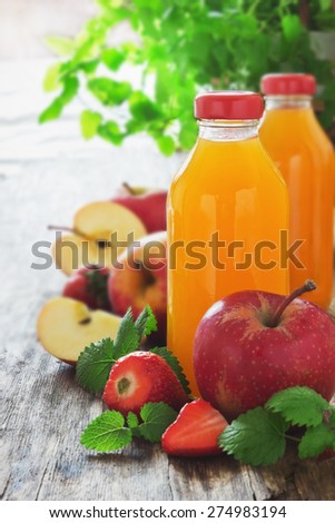 fruit juice, ripe apples and strawberries on old wooden table. fresh fruit from the garden.selective focus