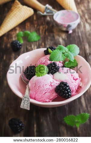 ice cream in a bowl ripe blackberries and mint leaves on the table. summer treats. selective focus