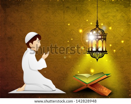 Little Muslim boy in traditional dress praying( reading Namaj, Islamic Prayer) with Islamic religious holy book Quran Shareef in the light of intricate arabic lamp.