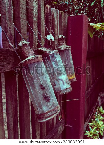vintage oil lamps hanging on the fence style background magenta color