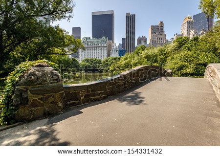 View of Central Park South from Gatstow Bridge. The bridge spans The Pond on a quiet morning in Central Park springtime.