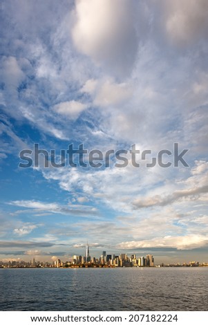 Light after the storm over downtown Manhattan, New York City. Clouds and downtown Manhattan skyscrapers. View of Manhattan southern tip, Battery Park, the Financial District and New York Harbor.
