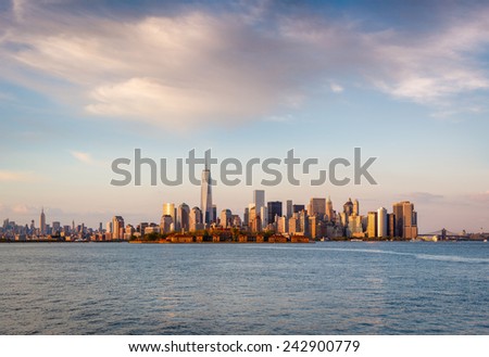 Late afternoon view of New York's majestic skyscrapers and Downtown Manhattan. Warm, glowing light flooding Lower Manhattan scenery, including the Financial District, Battery Park and Ellis Island.