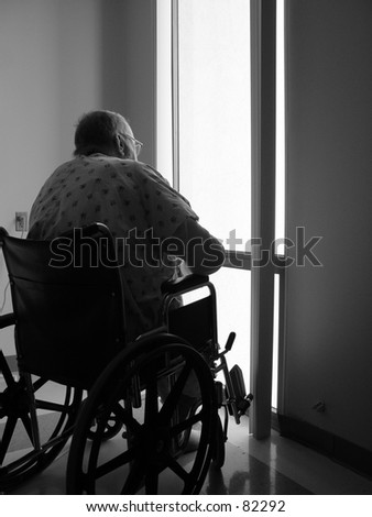 Elderly man peering from hospital window.
