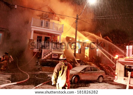 TORONTO - CIRCA JANUARY 2010 - Firefighters battle a four alarm fire involving three homes in the Beach neighborhood of the city.